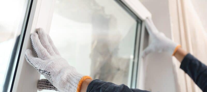 hands installing new windows while wearing gloves