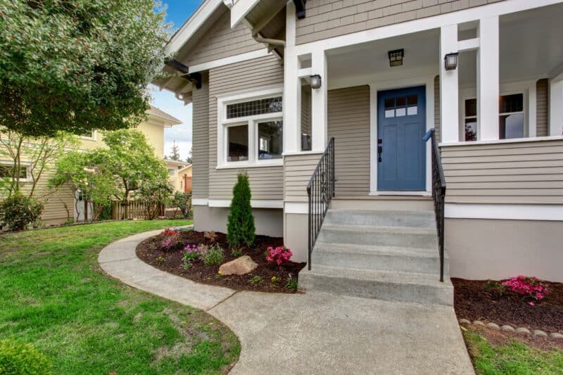 House exterior with entrance porch. View of staircase and front yard landscape