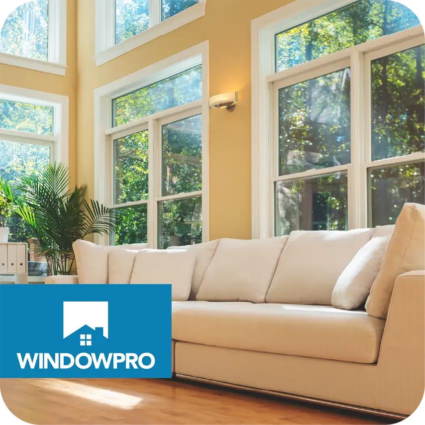 Bright living room with large windows and a cream sofa, featuring the WindowPro logo